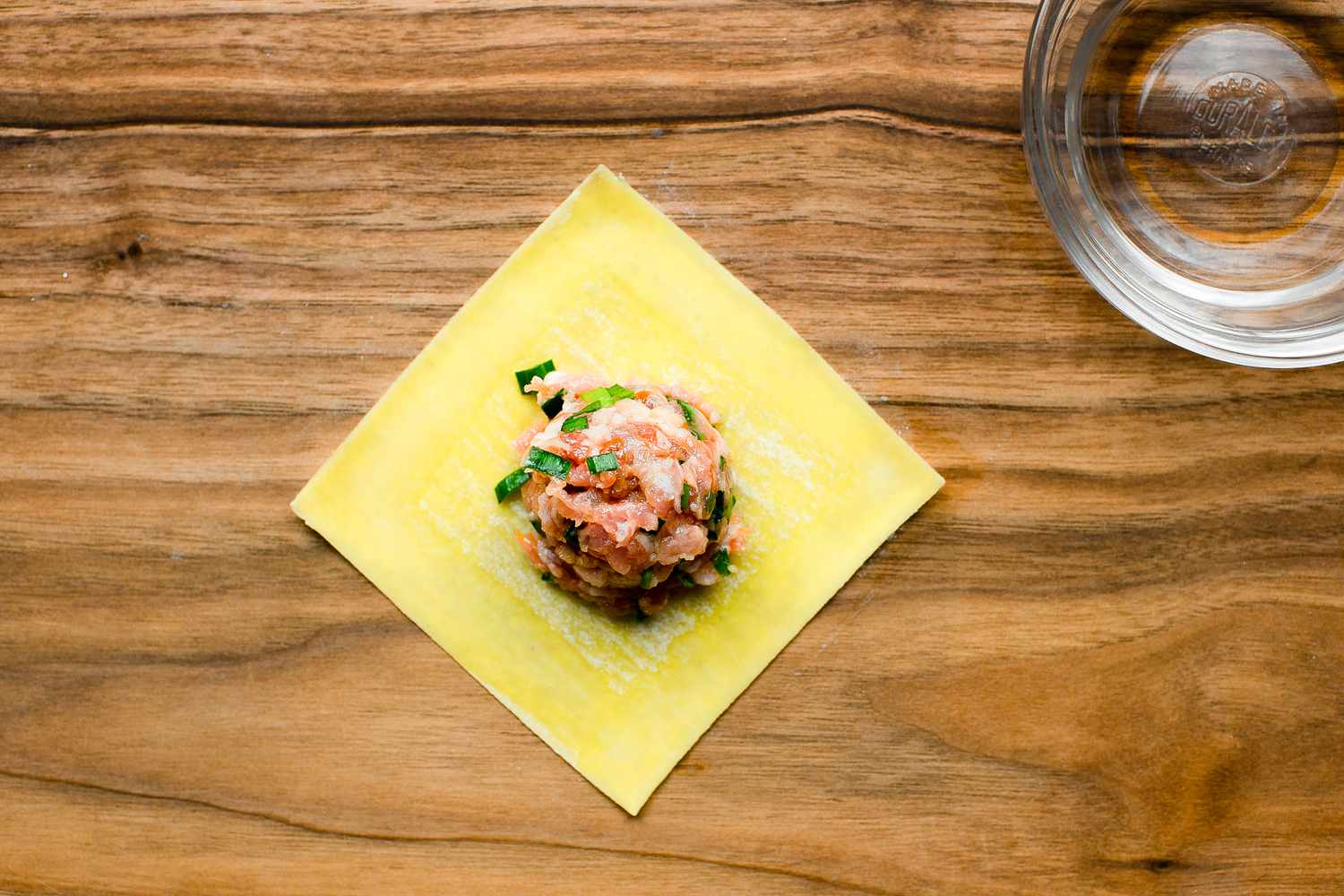 Tablespoon of Pork and Chive Filling in Dumpling Wrapper with Edges Brushed with Water for Dumpling Recipe