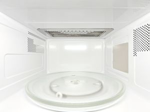 Frontal view inside white, empty clean microwave oven interior