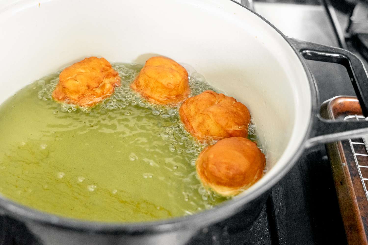 Sufganiyot (Israeli Jelly Donuts) Frying in a Pot of Hot Oil on the Stove