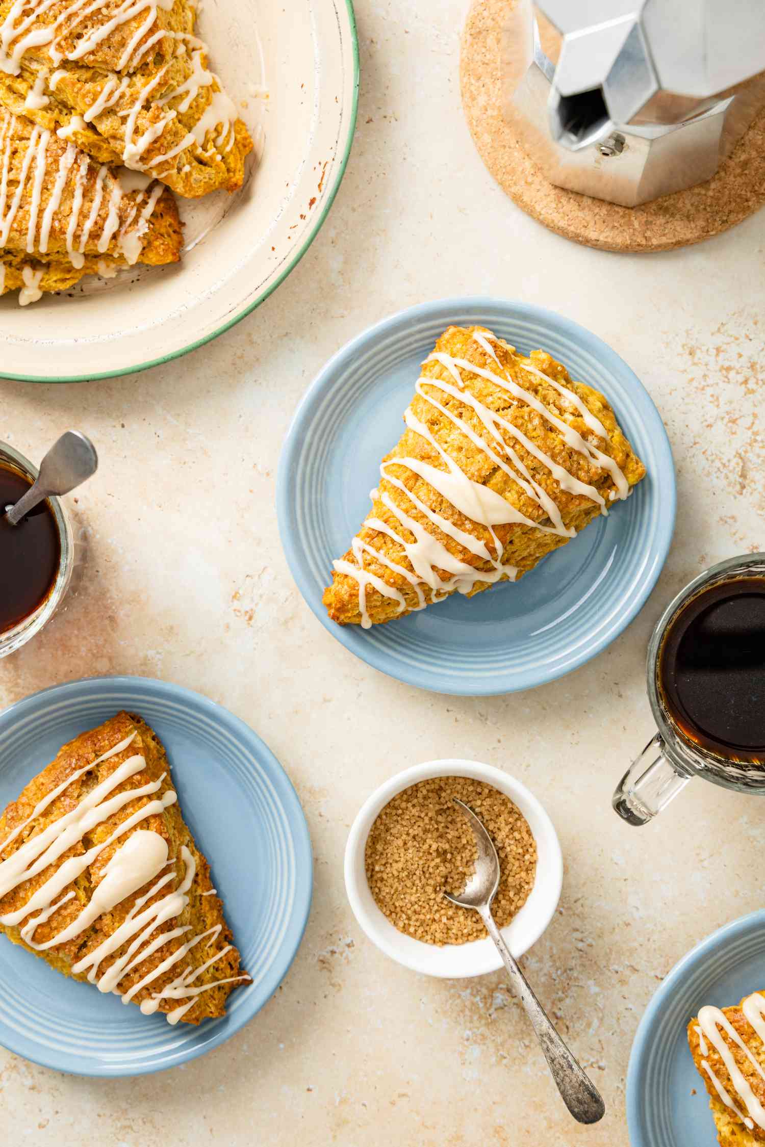 Pumpkin Scones on a Plate Surrounded by Cups of Coffee