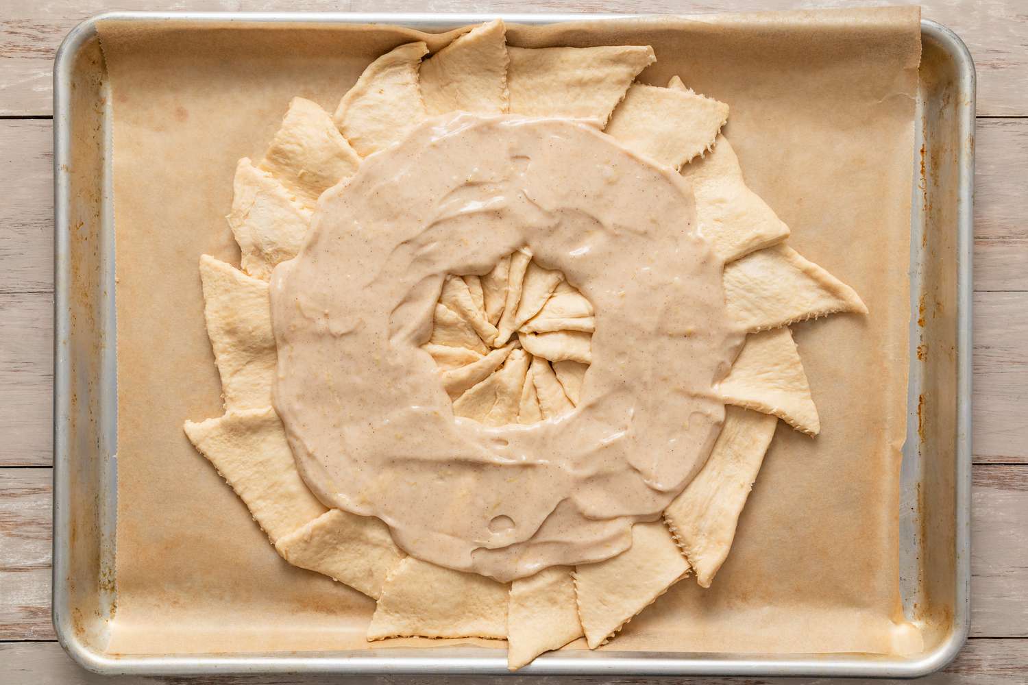 Filling spread evenly in a ring on the arranged crescent dough for king cake recipe 