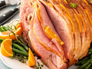 Spiral sliced glazed ham stuffed with orange slices and herbs