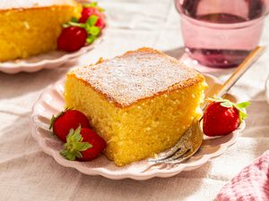 A slice of cake on a plate with strawberries and a fork