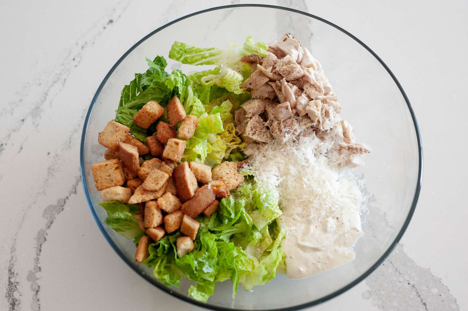 Chicken, Romaine Lettuce, Croutons, Caesar Dressing, and Parmesan Cheese in a Bowl for Caesar Chicken Wrap Recipe