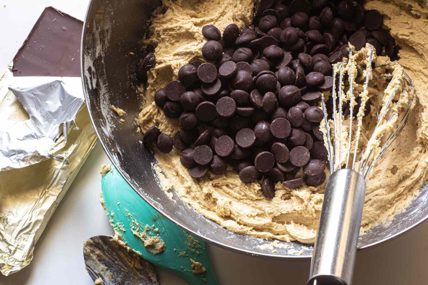 bowl with cookie dough, whisk, and chocolate chips