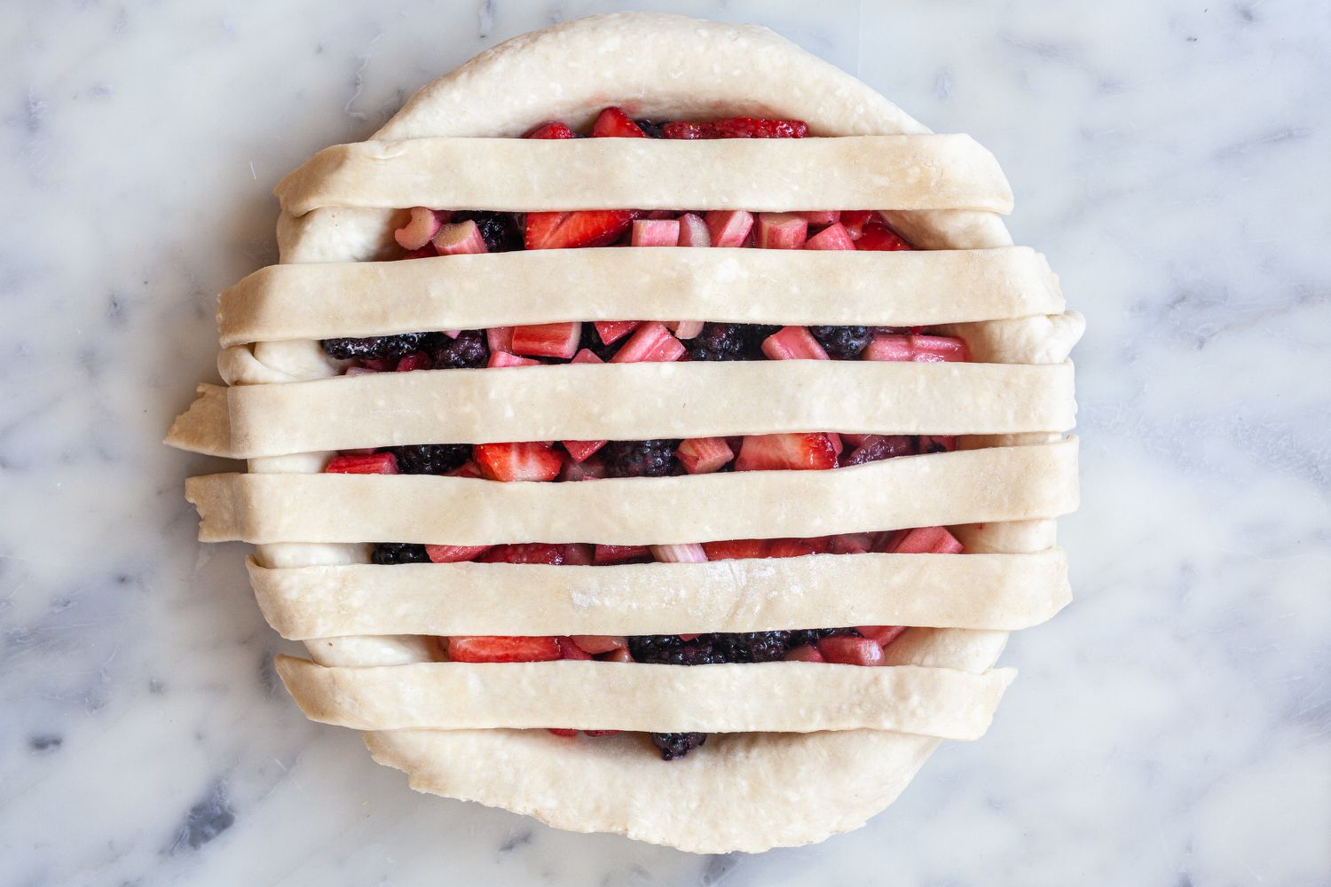 Laying strips over filling to show how to make a lattice crust.