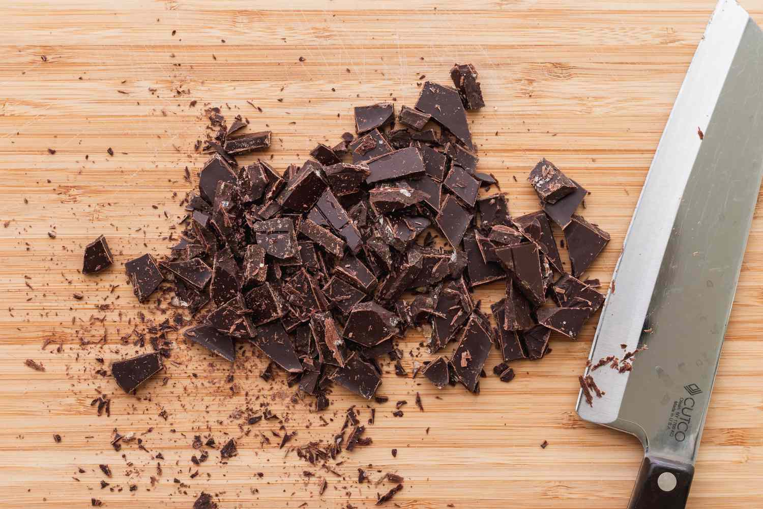 Chopping chocolate to make classic vegan chocolate chip cookies