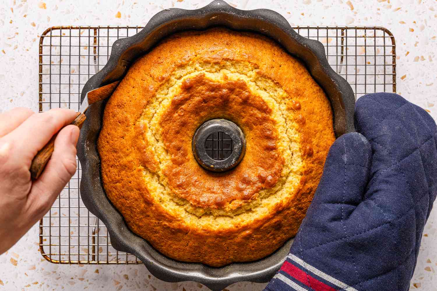 offset spatula run along the side of the ciambellone in the bundt pan 