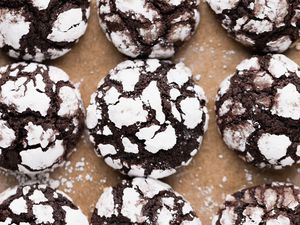 Overhead view of chocolate crinkle cookies on a lined baking pan