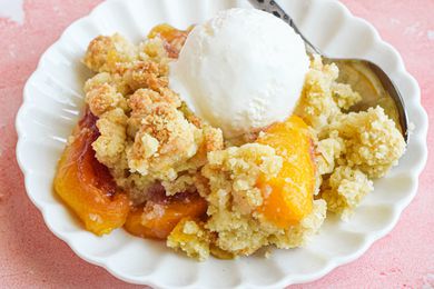 A Small Plate of Peach Cobbler Topped with a Scoop of Vanilla Ice Cream