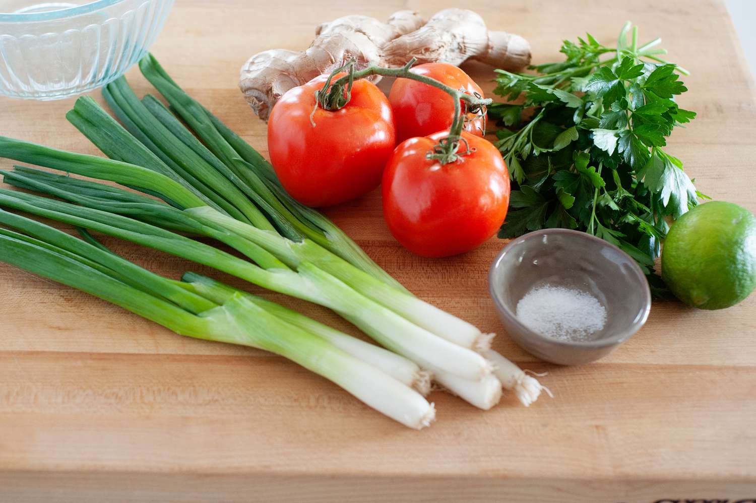 Ingredients to make Hawa Hassan’s Lasary Legioma (Tomato Relish) Recipe set on a wooden cutting board.