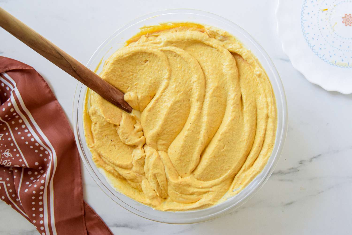 2-ingredient pumpkin mousse in a bowl with a spatula next to a brown kitchen linen