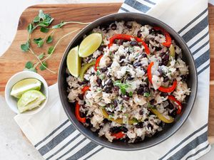 A bowl of black bean rice on a striped linen.