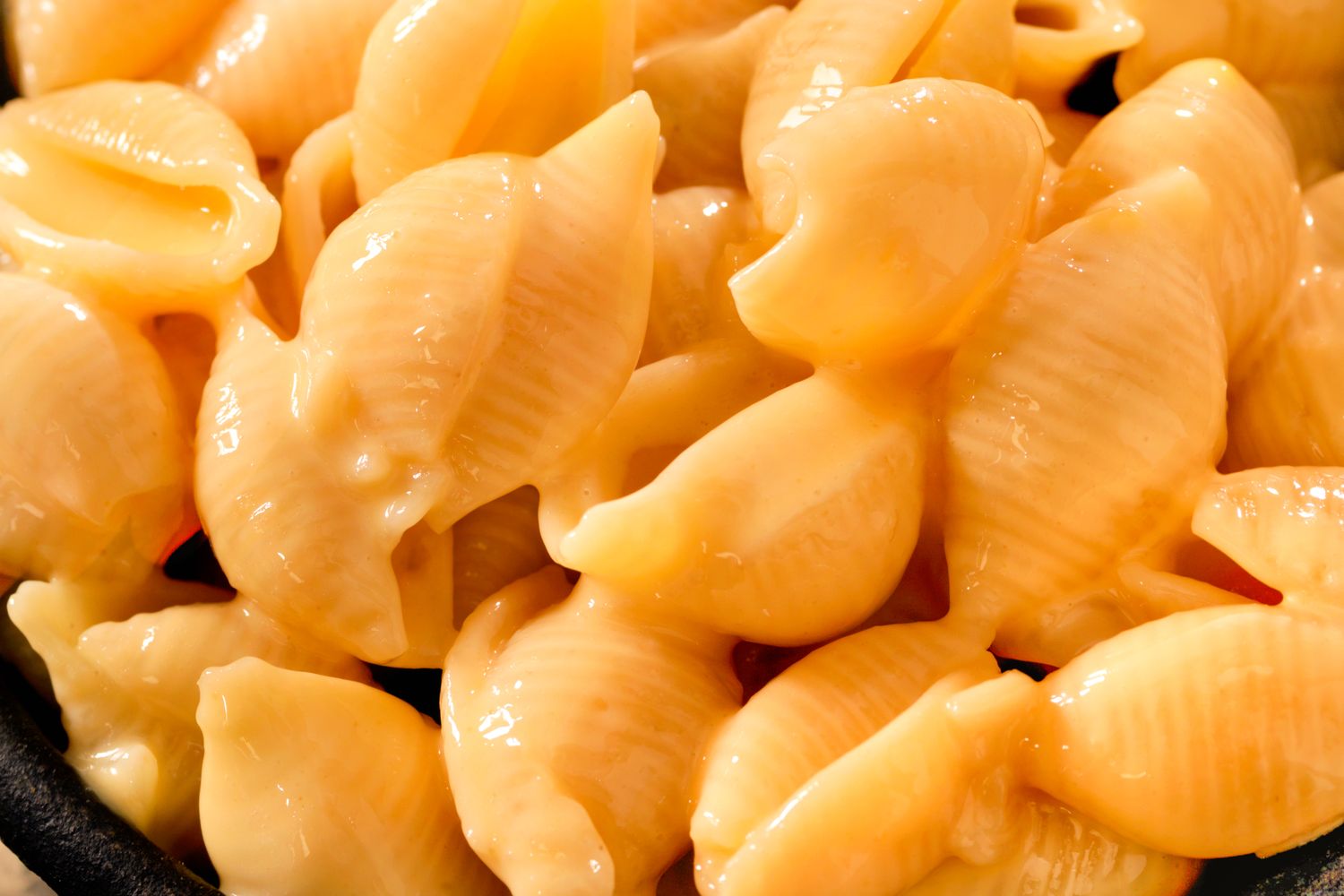 Closeup view of creamy macaroni and cheese with shellshaped pasta