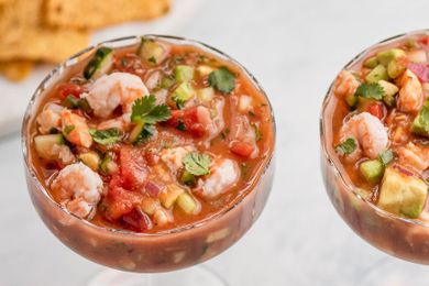 Overhead view of two stemmed glasses full of Mexican shrimp cocktail