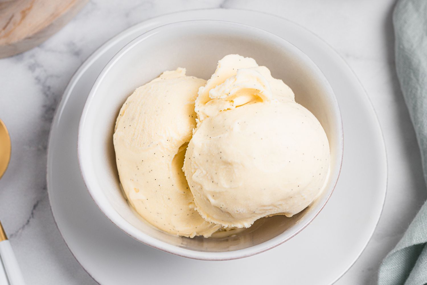 Two scoops of homemade ice cream recipe in a bowl.
