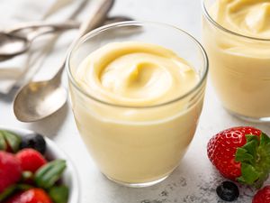 Vanilla Custard in Pudding Jars Surrounded by Spoons and Berries