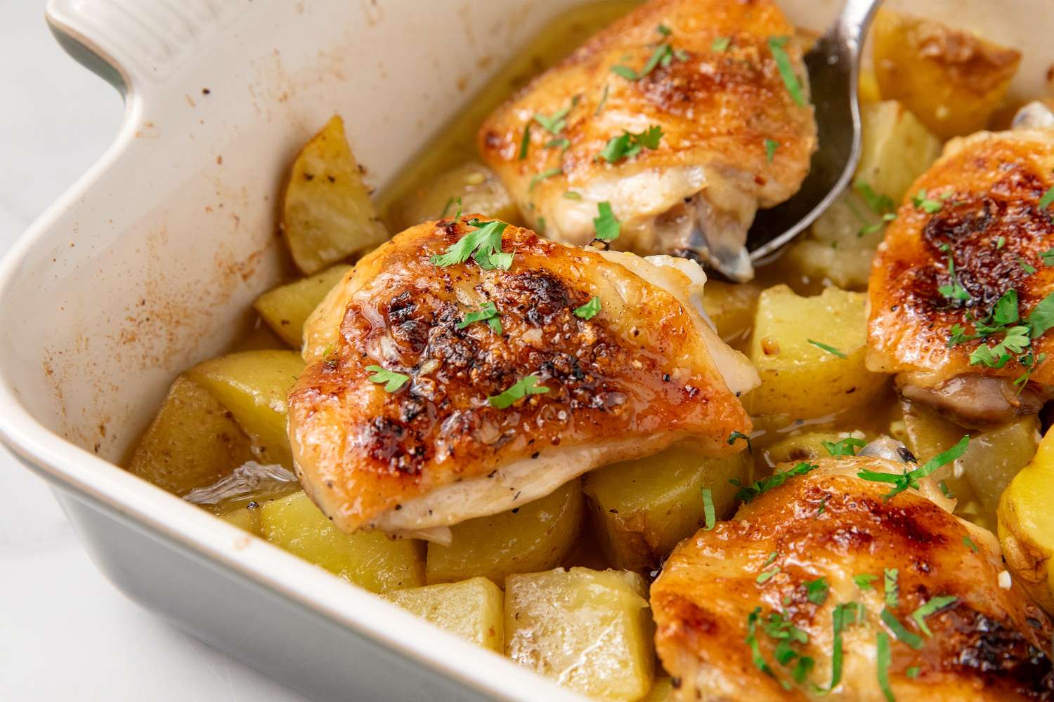 Baked chicken thighs with potatoes in a casserole dish