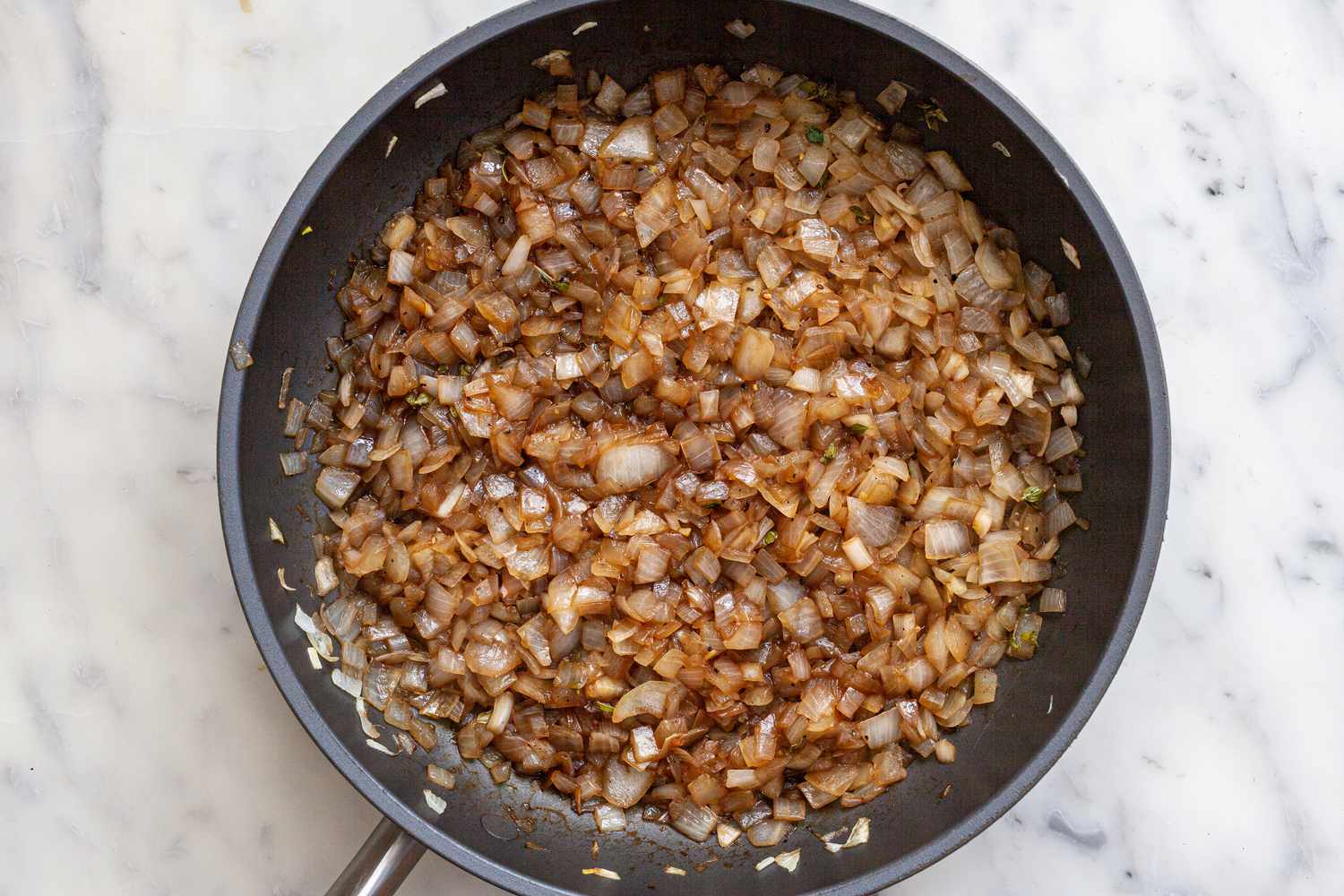 Sauteed onions in a skillet to make an Onion jam recipe with balsamic vinegar.