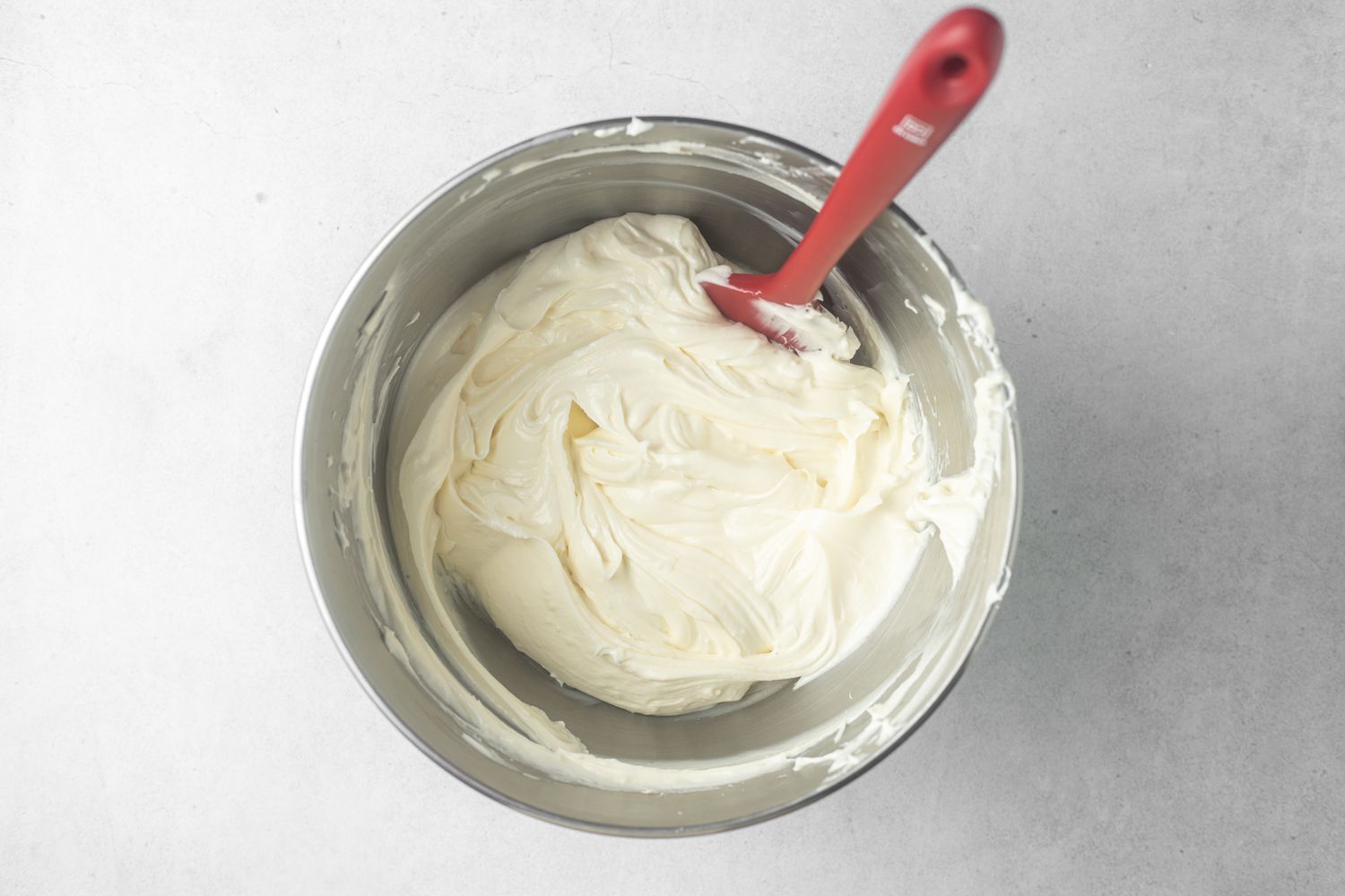 Making the feeling for pumpkin cheesecake in a metal bowl.