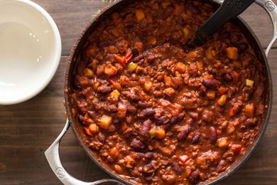 A pot with chili on a wooden surface