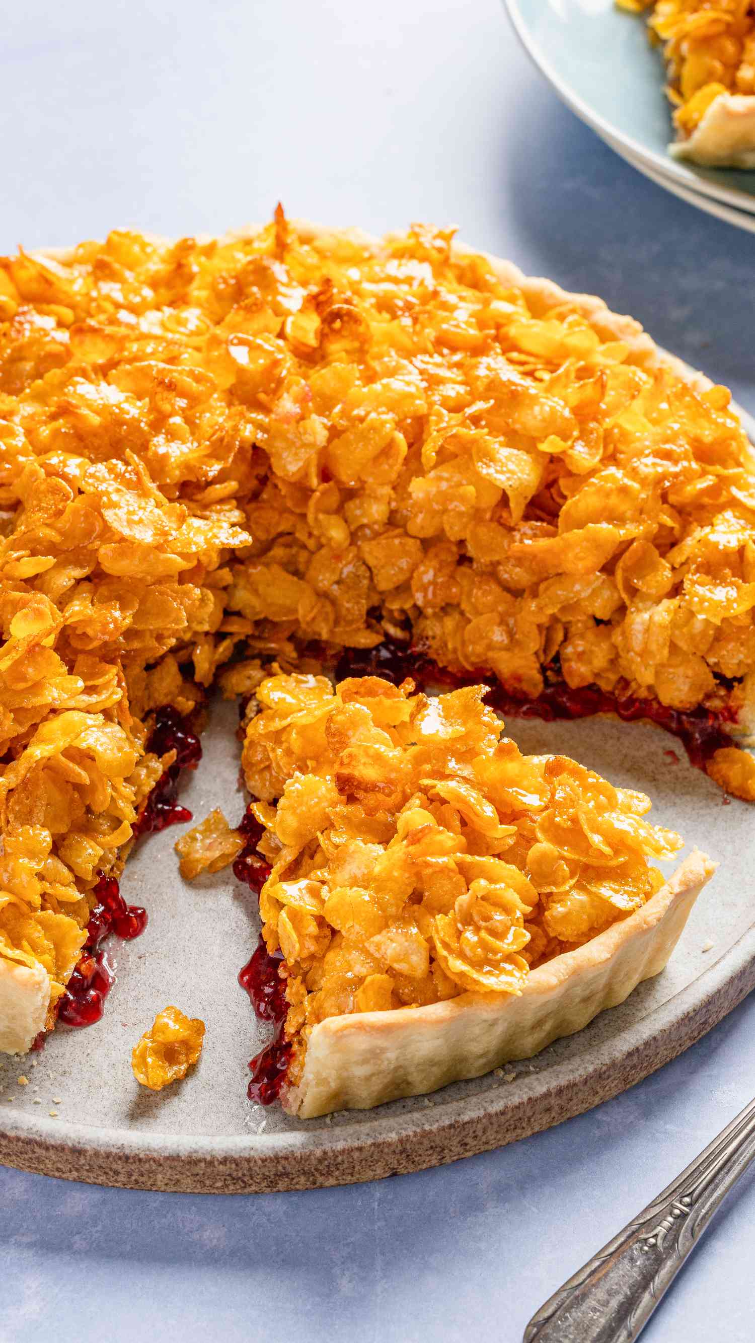 Cornflake tart (part of it sliced and missing a piece) on a plate