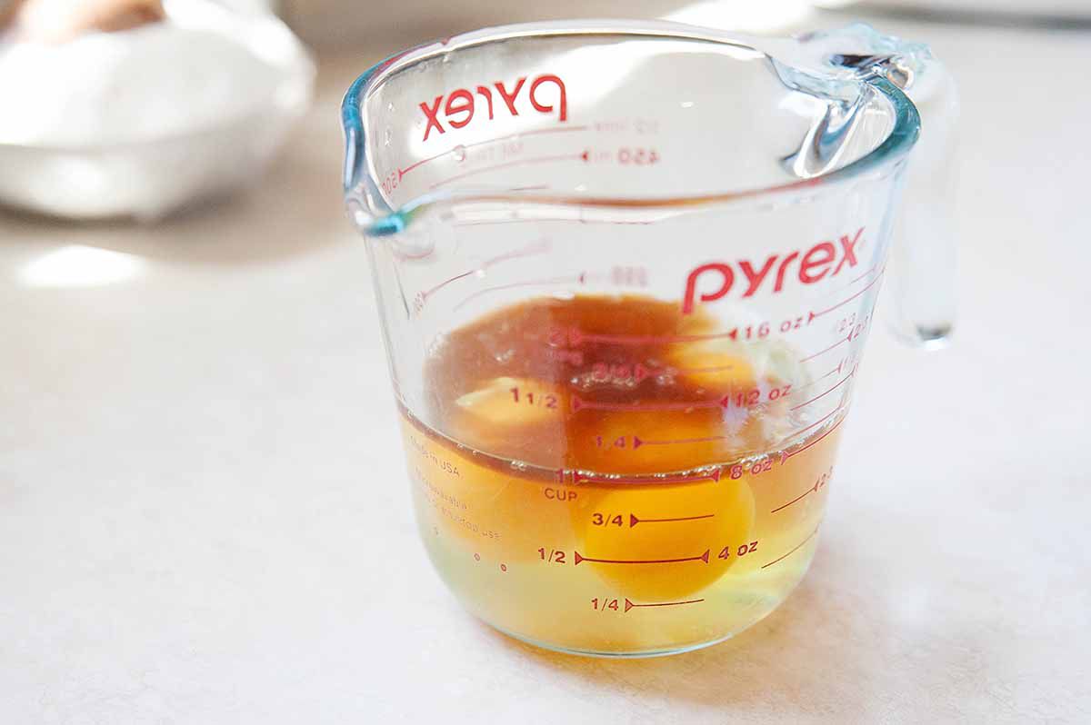 Eggs, and vanilla in a pyrex liquid measuring cup.
