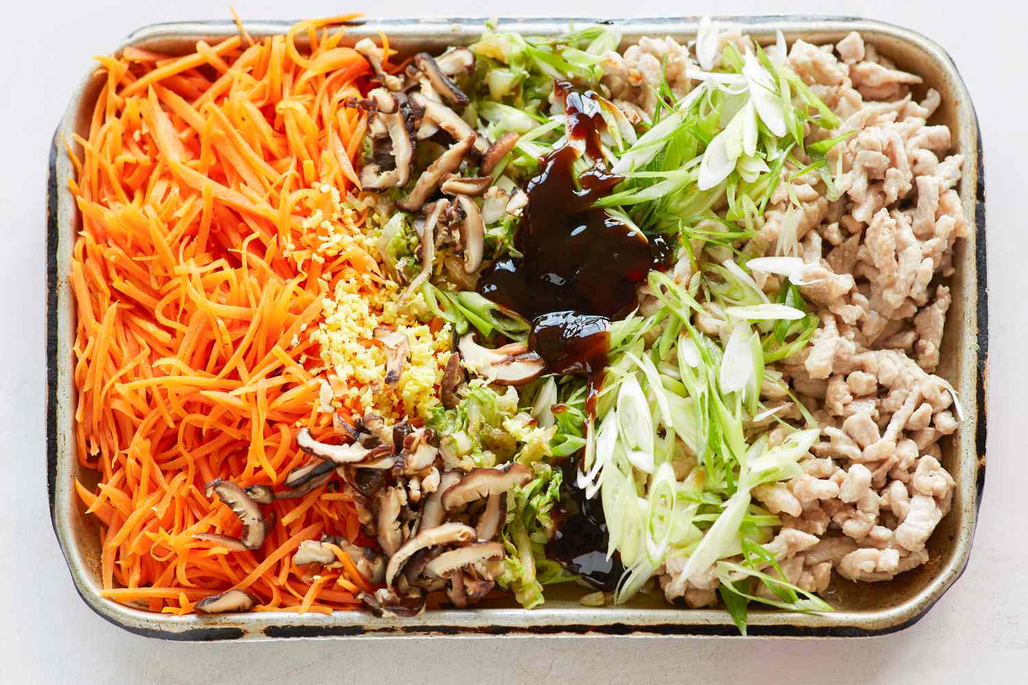 Sheet pans with vegetables to make the filling for spring rolls.