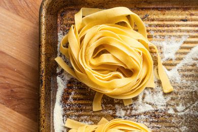 Unrolled Tagliatelle Bundles on a Semolina Dusted Baking Sheet