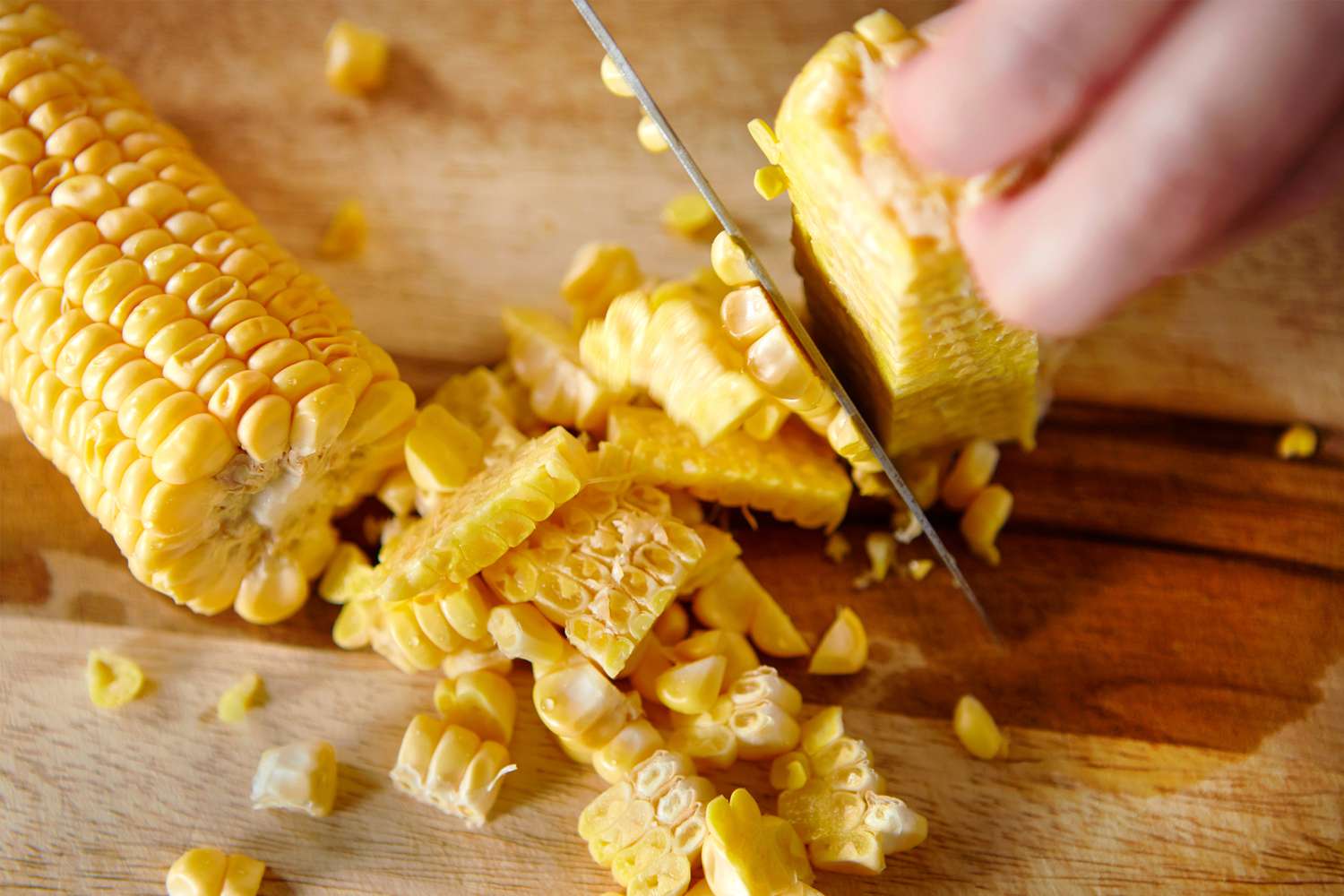 Cutting kernels off a cob of corn with a knife