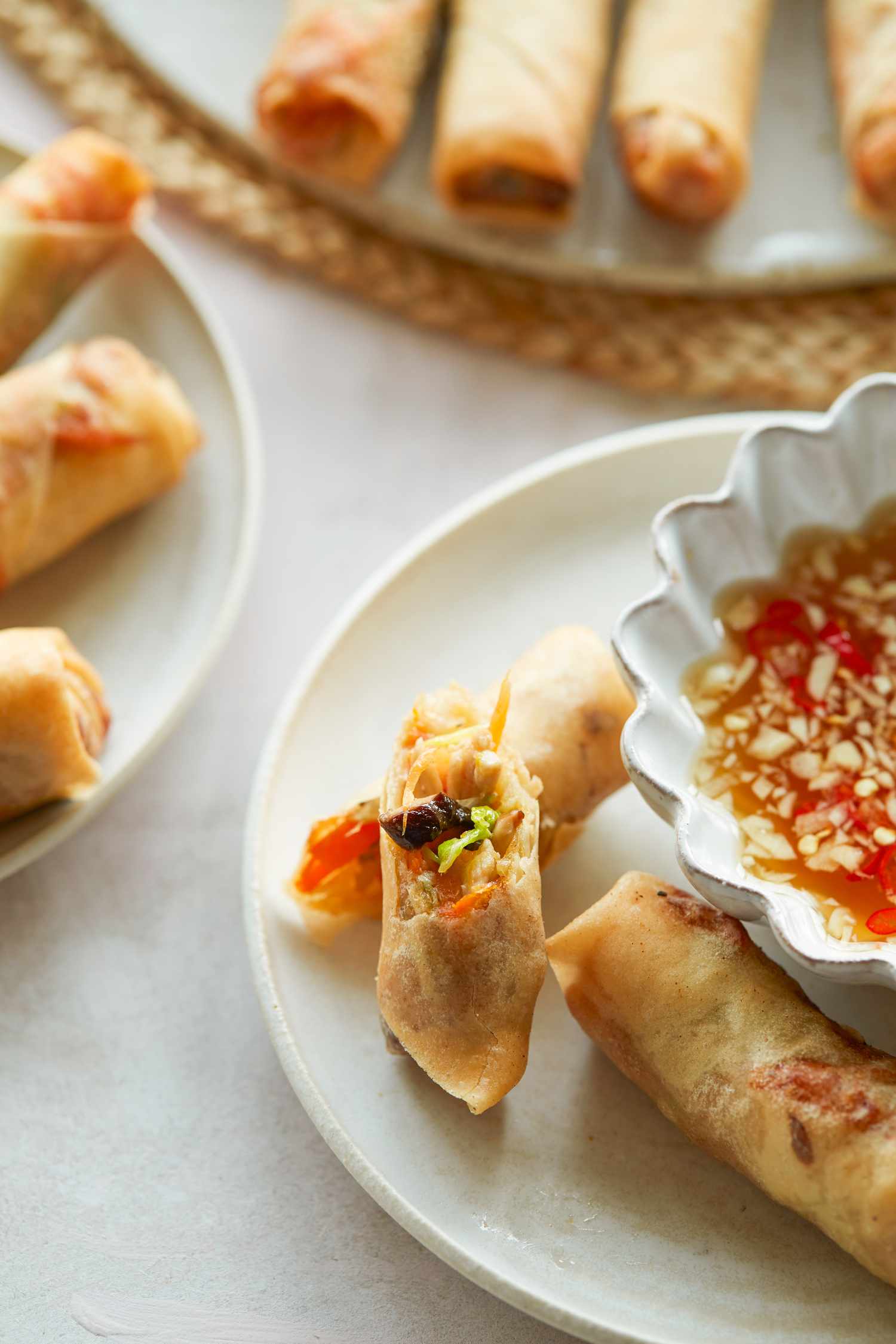 Spring rolls on a plate with a dipping sauce.