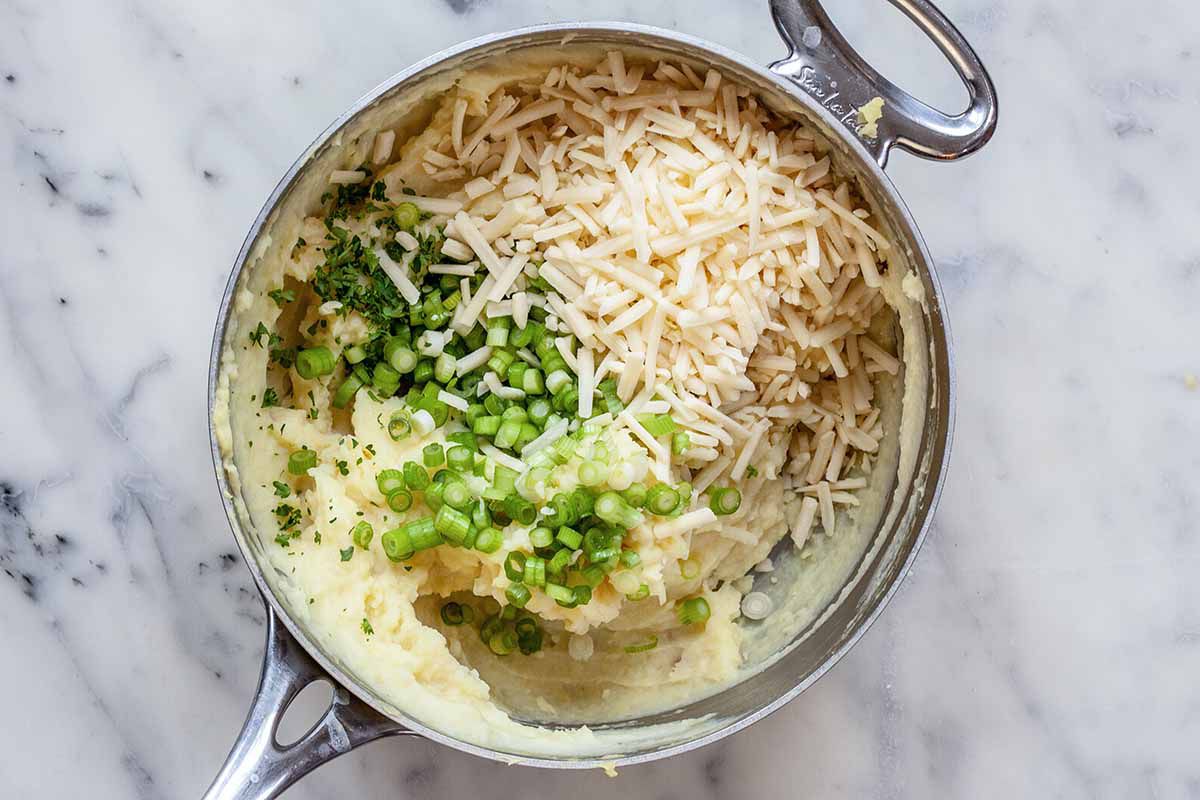 Easy Vegetarian Cottage Pie -- silver pot with mashed potatoes, cheese and chopped scallions