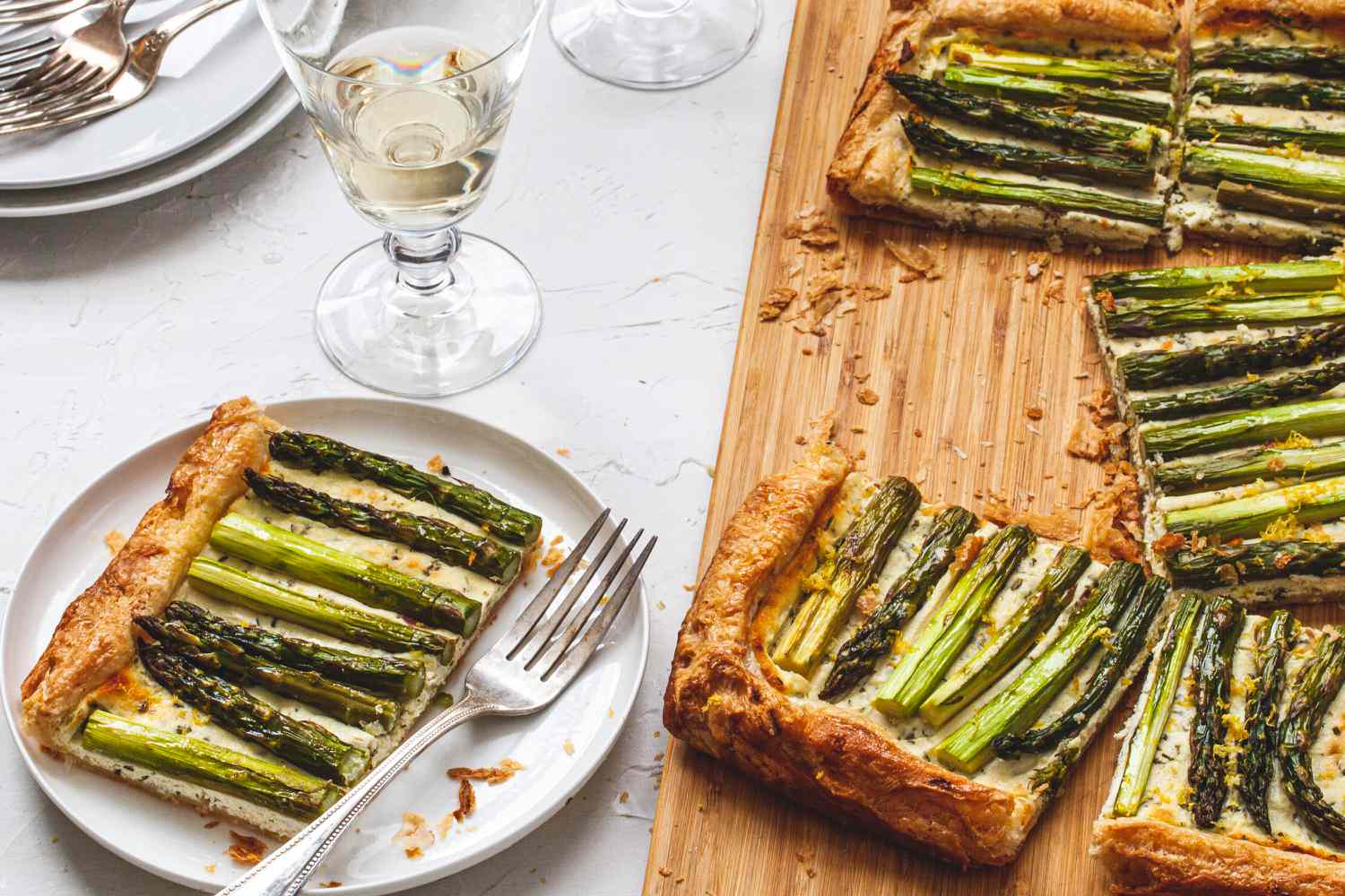 Easy Asparagus Tart on a cutting board and a piece served on a plate.