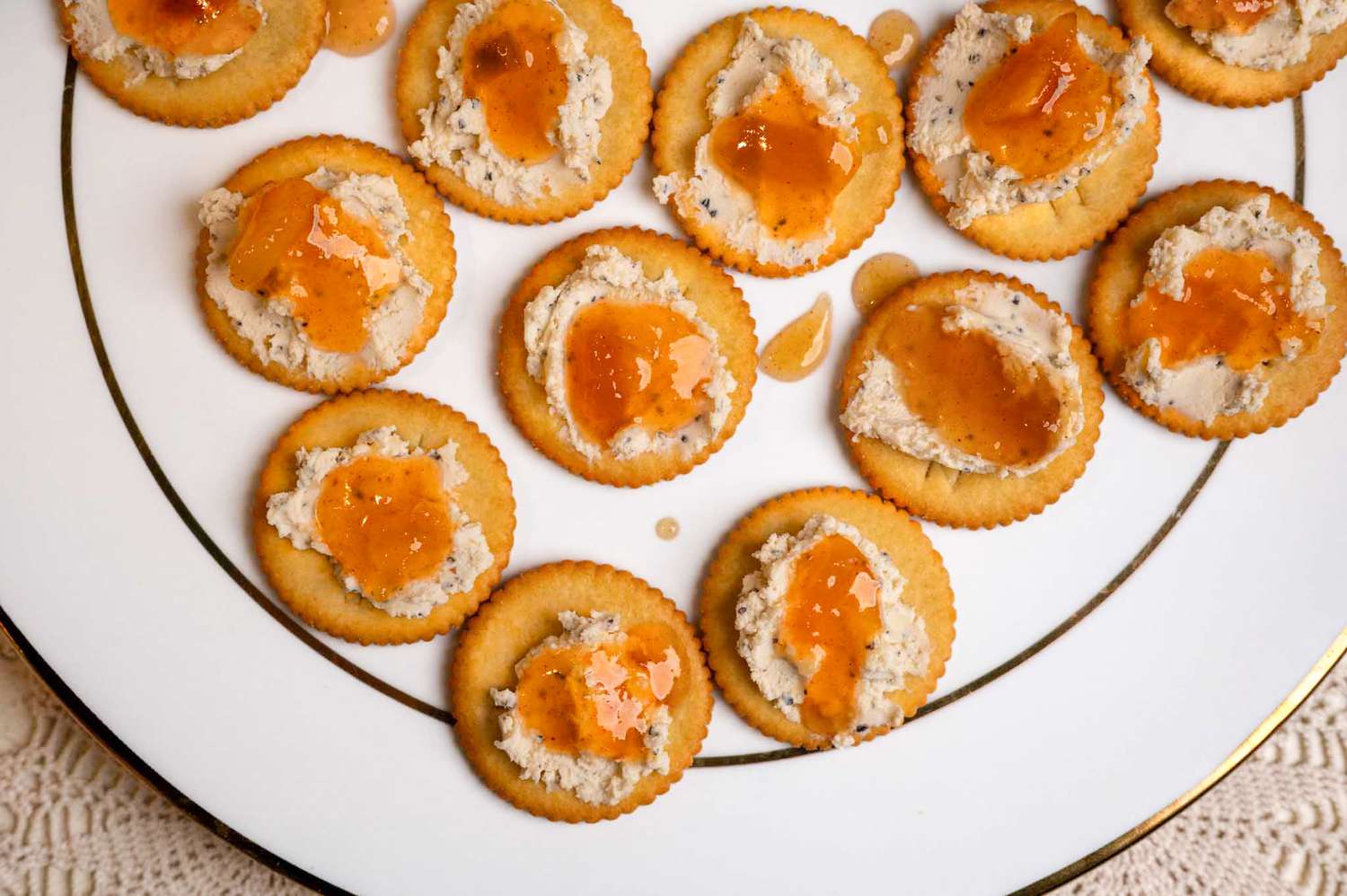 Overhead view of a white plate of Ritz crackers topped with Boursin cheese and mango chutney