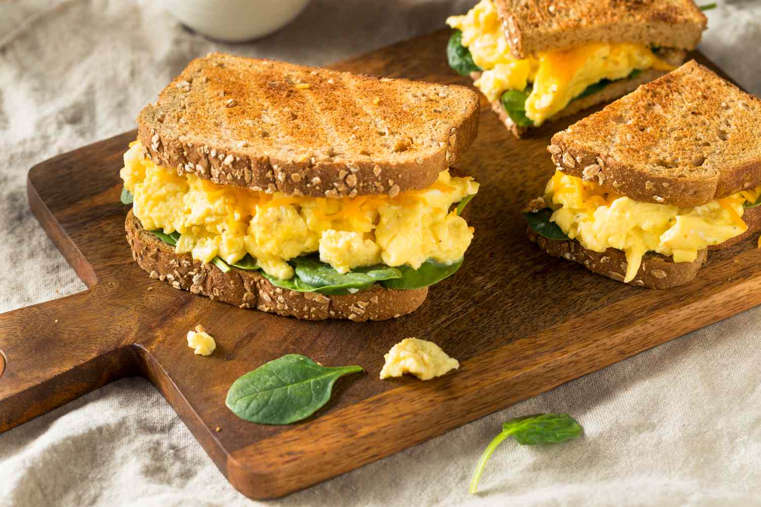 scrambled egg sandwich on a wooden board