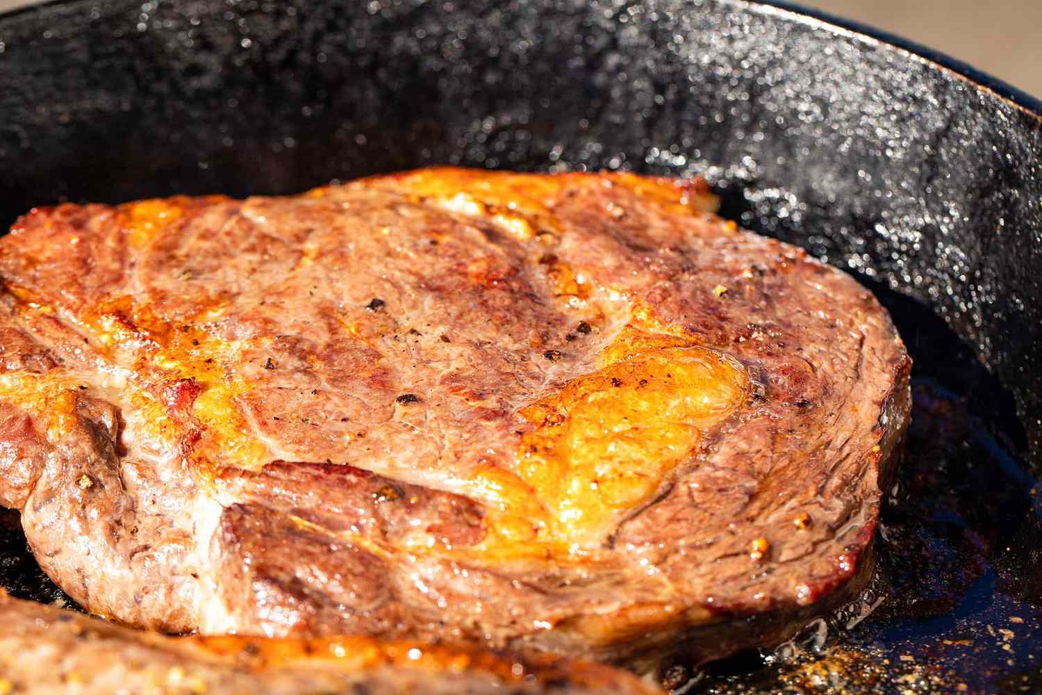 Cast iron skillet with pork chops cooked inside.