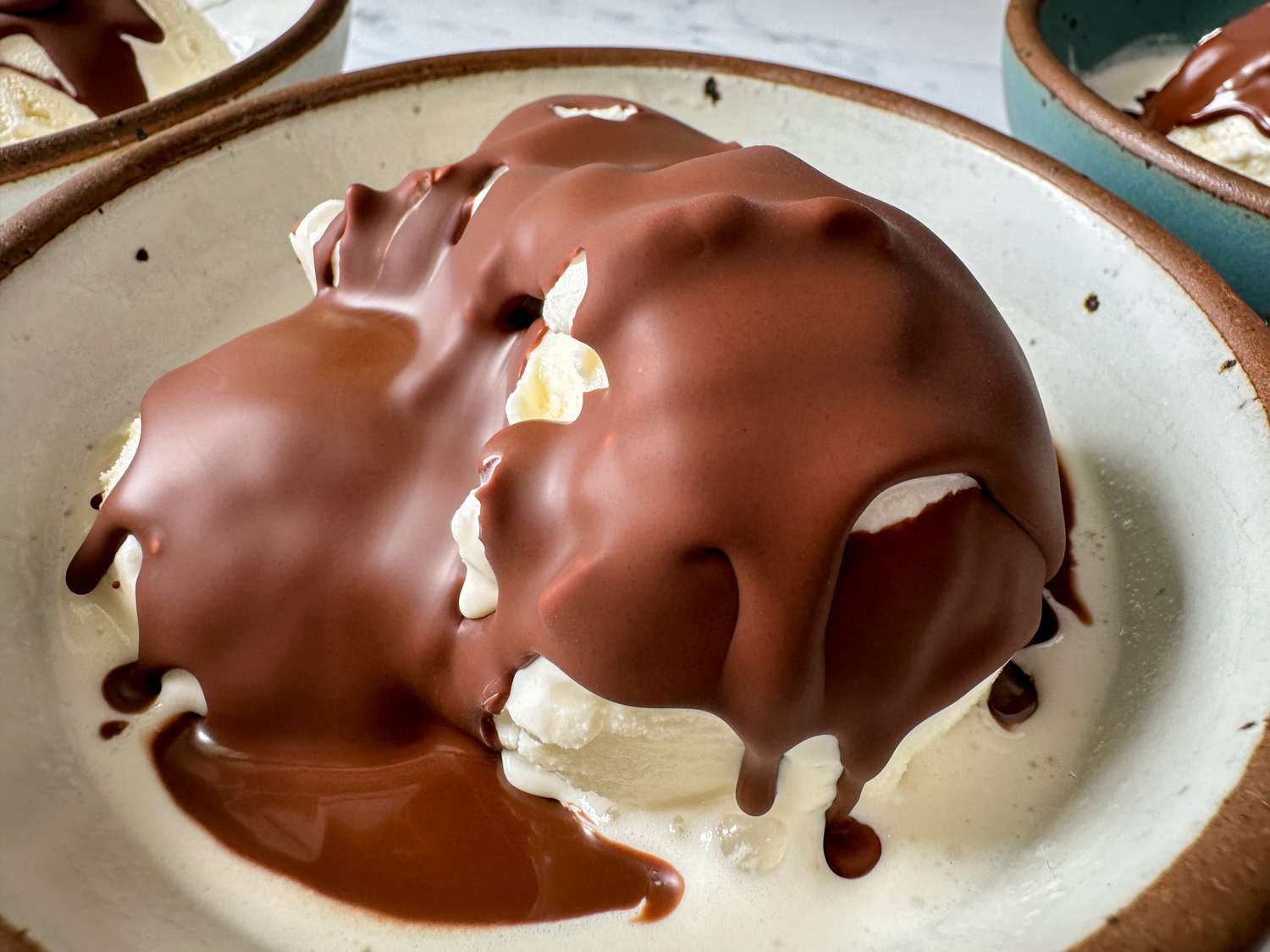 A dessert with ice cream drizzled in chocolate shell sauce