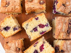 Overhead view of multiple blueberry coffee cake slices on a wooden cutting board