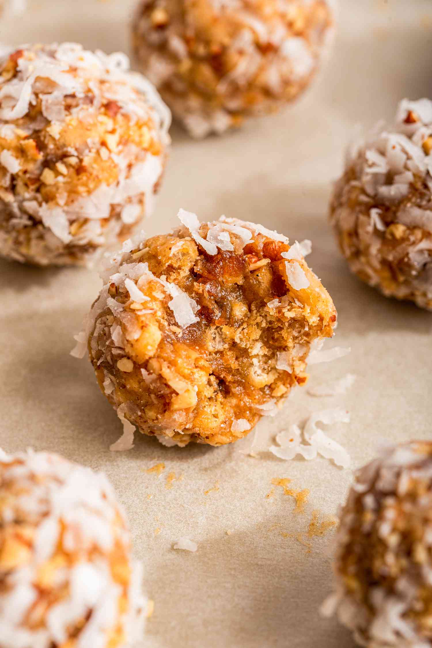 Close-up: date skillet cookies on a baking sheet with one date skillet cookie bitten into