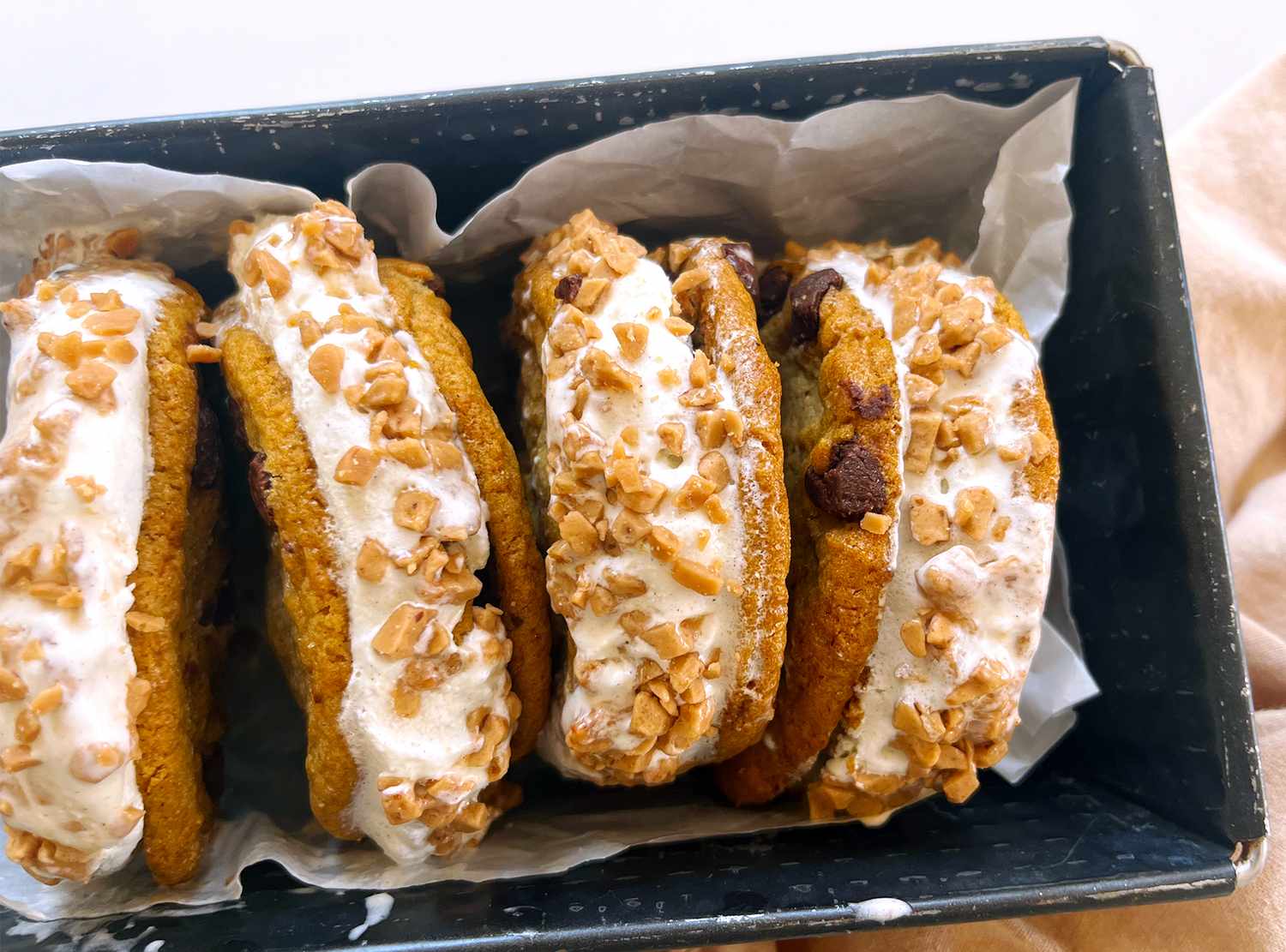 Ice cream sandwiches with cookie layers and toffee bits in a tray