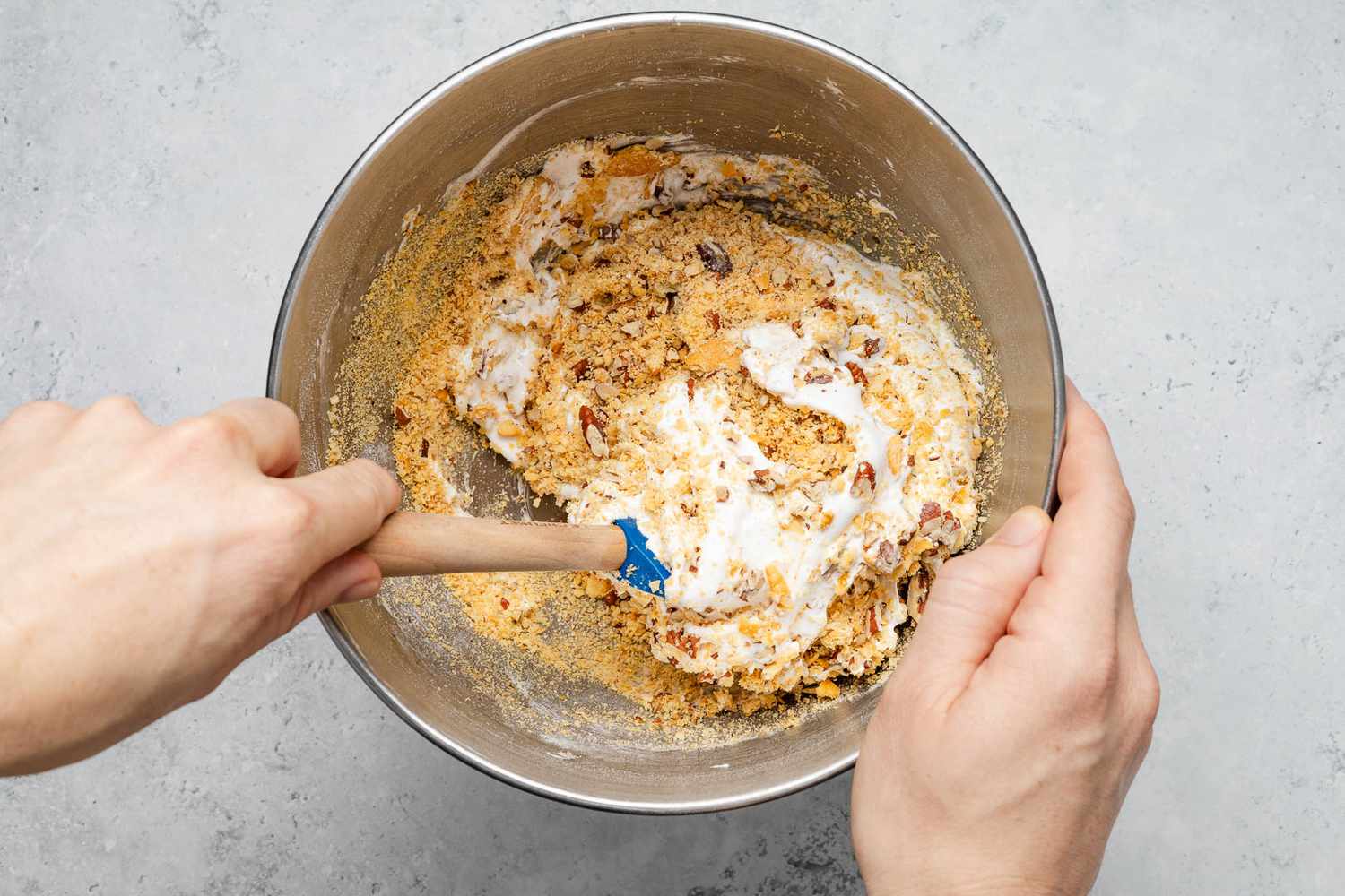 Crushed crackers and chopped pecans folded into the meringue using a spatula for ritz torte recipe