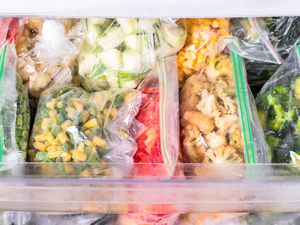 zip-top bags filled with frozen vegetables in a freezer 