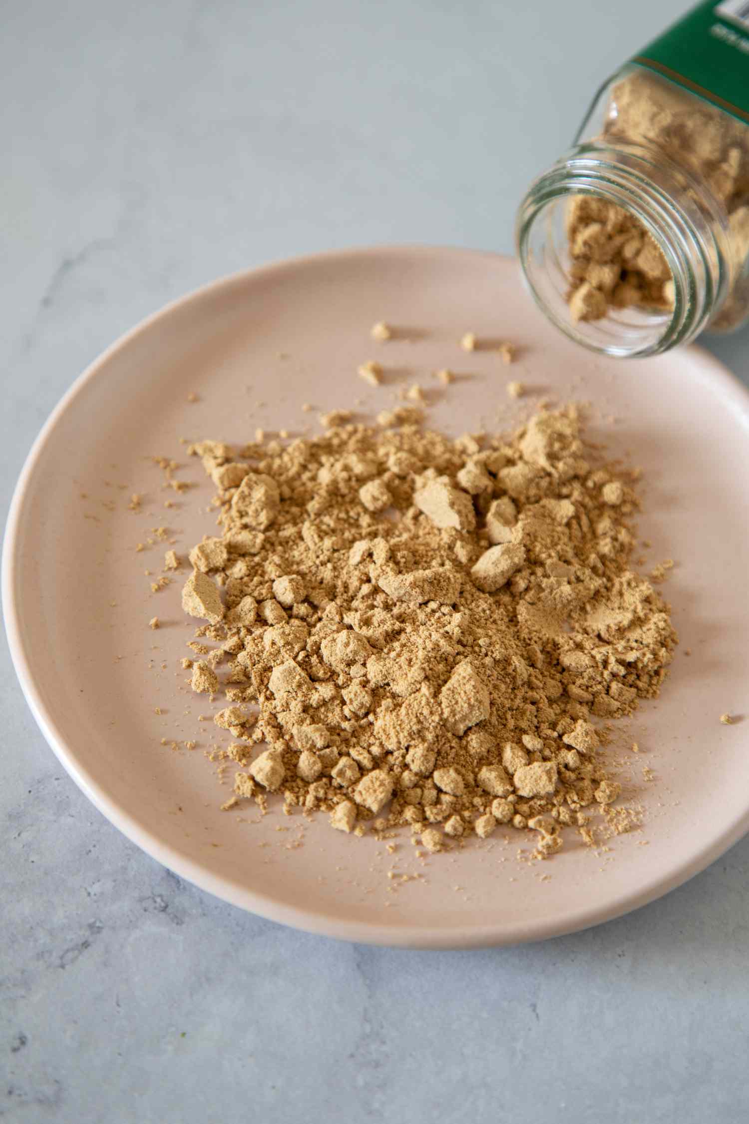 Ground ginger pouring on a plate