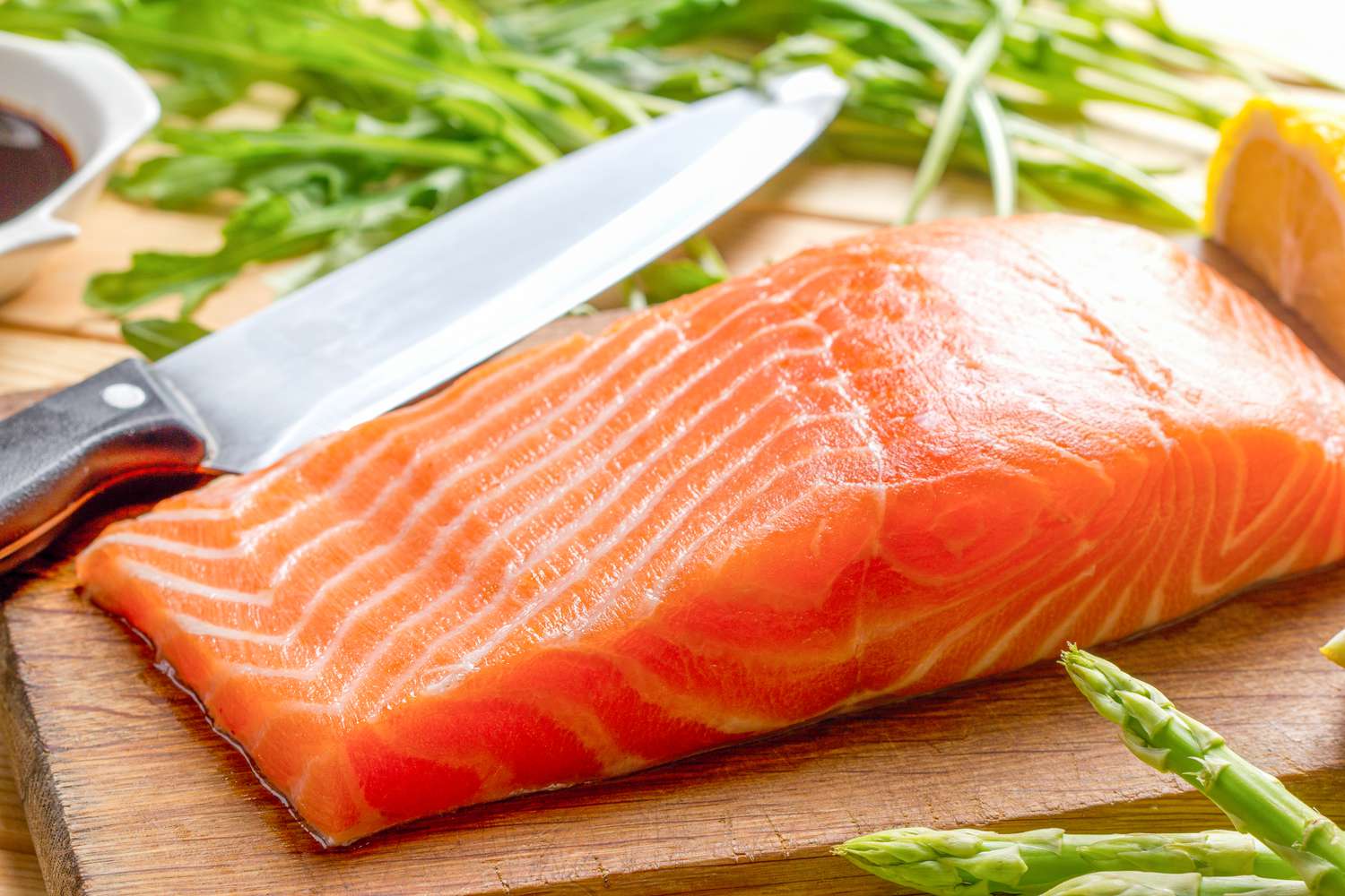 Side view closeup of a raw salmon fillet on a cutting board