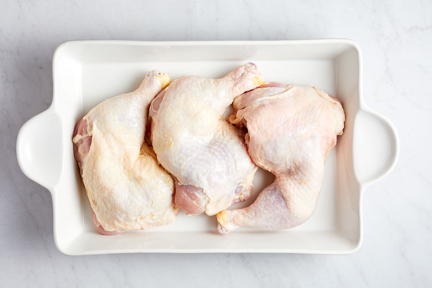 chicken quarters in a casserole dish for oven roasted piri piri chicken