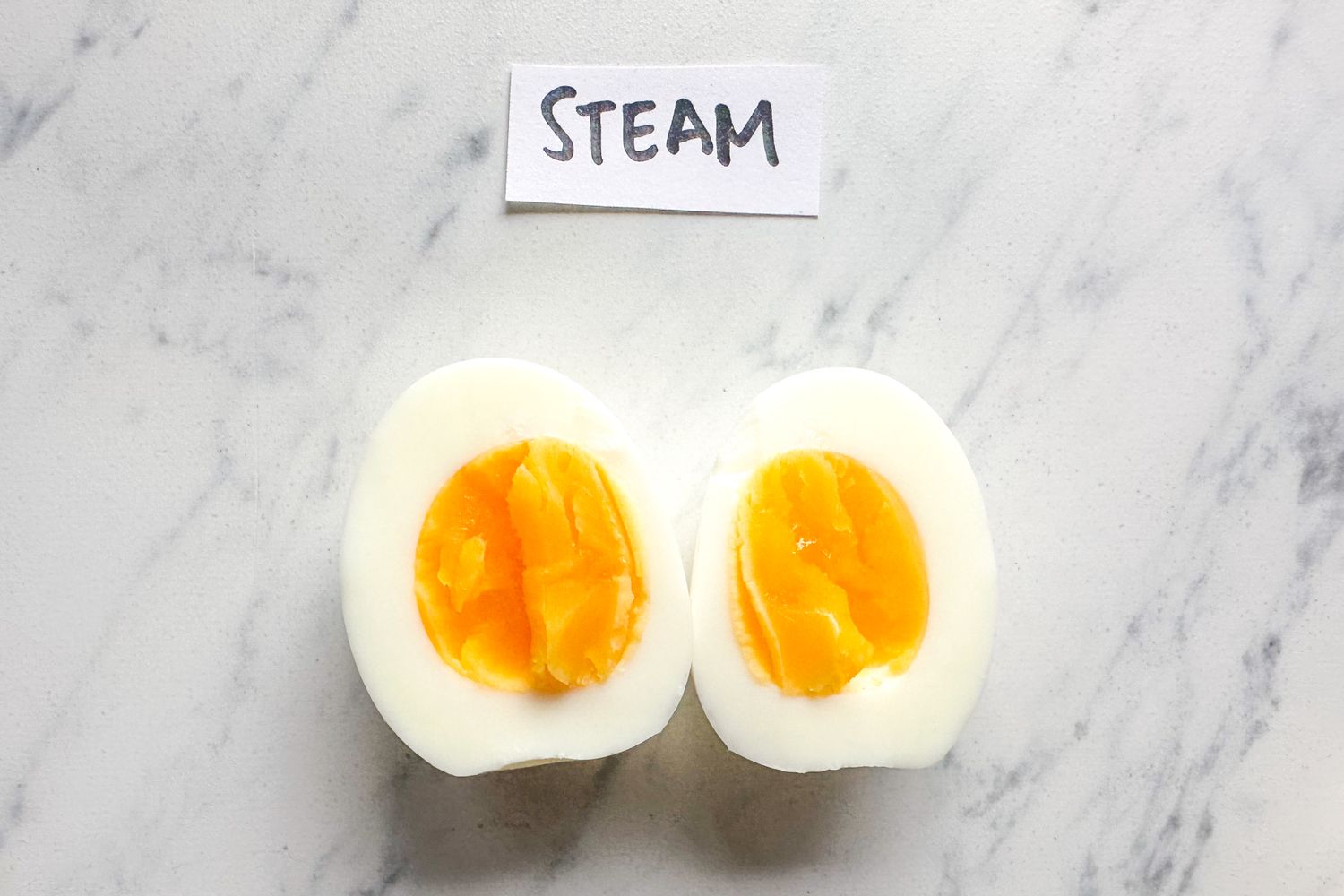 A sliced hardboiled egg with a label reading steam displayed above it