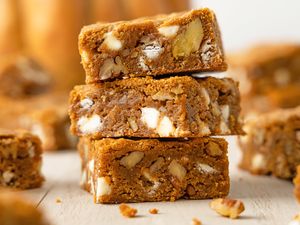 Stack of pumpkin blondies with white chocolate and nuts