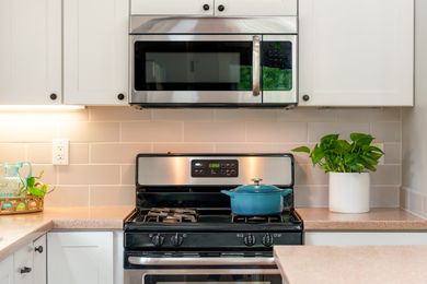 A kitchen stove and built in microwave above it