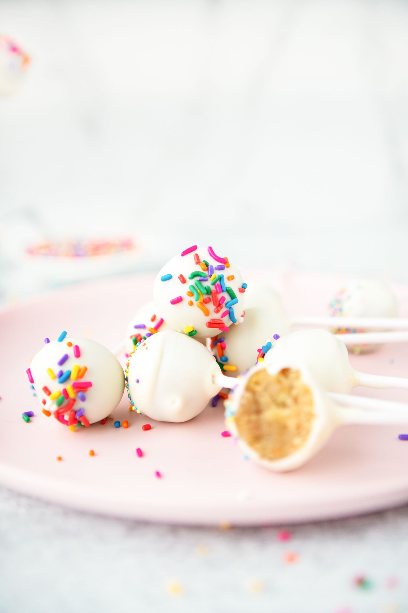 Cake Pops with Sprinkles on Plate with One Partially Eaten
