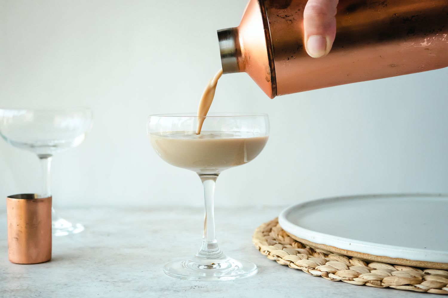 Pouring a Mudslide cocktail into a stemmed glass.
